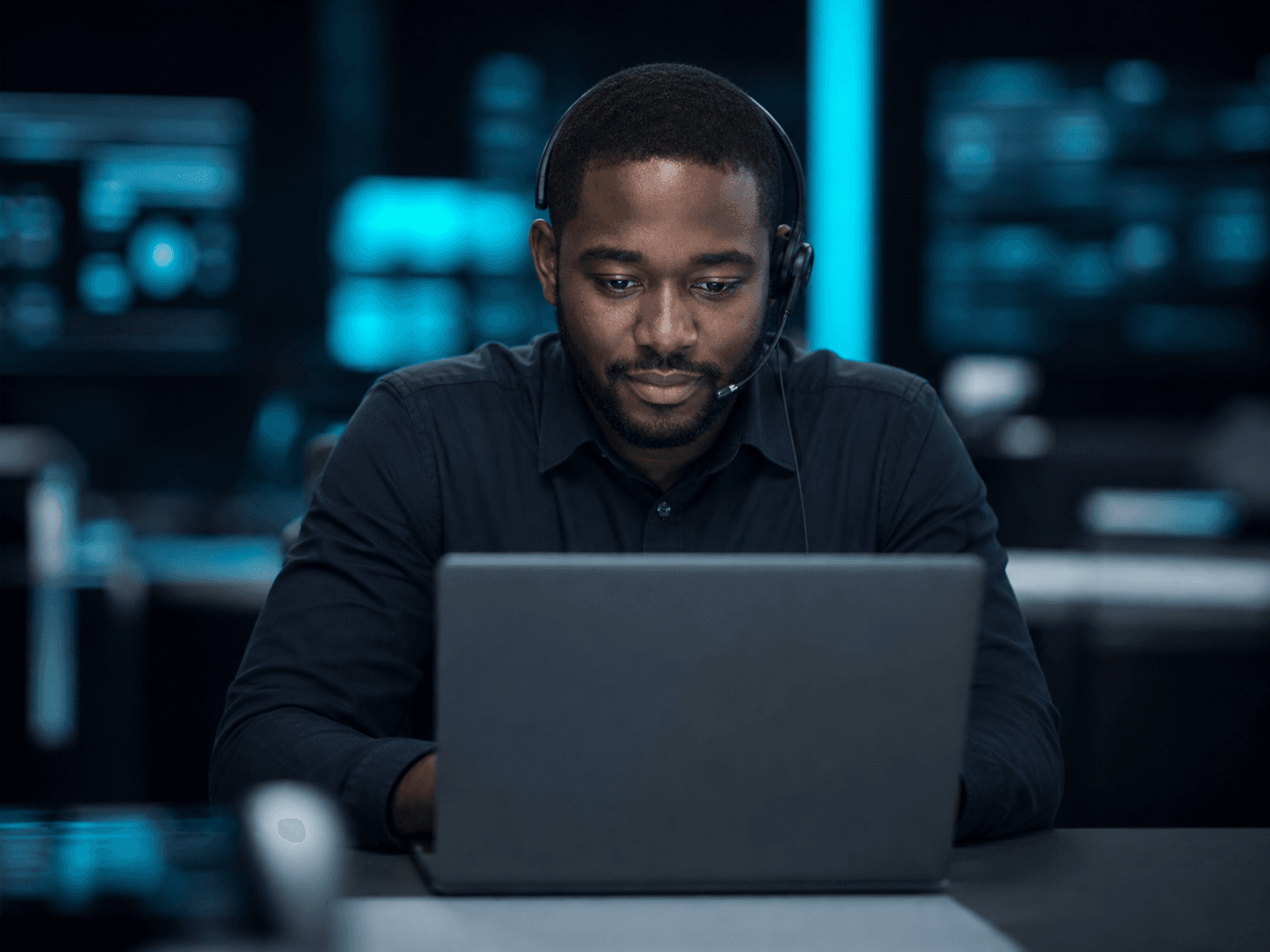 Support engineer on a call, working at a laptop